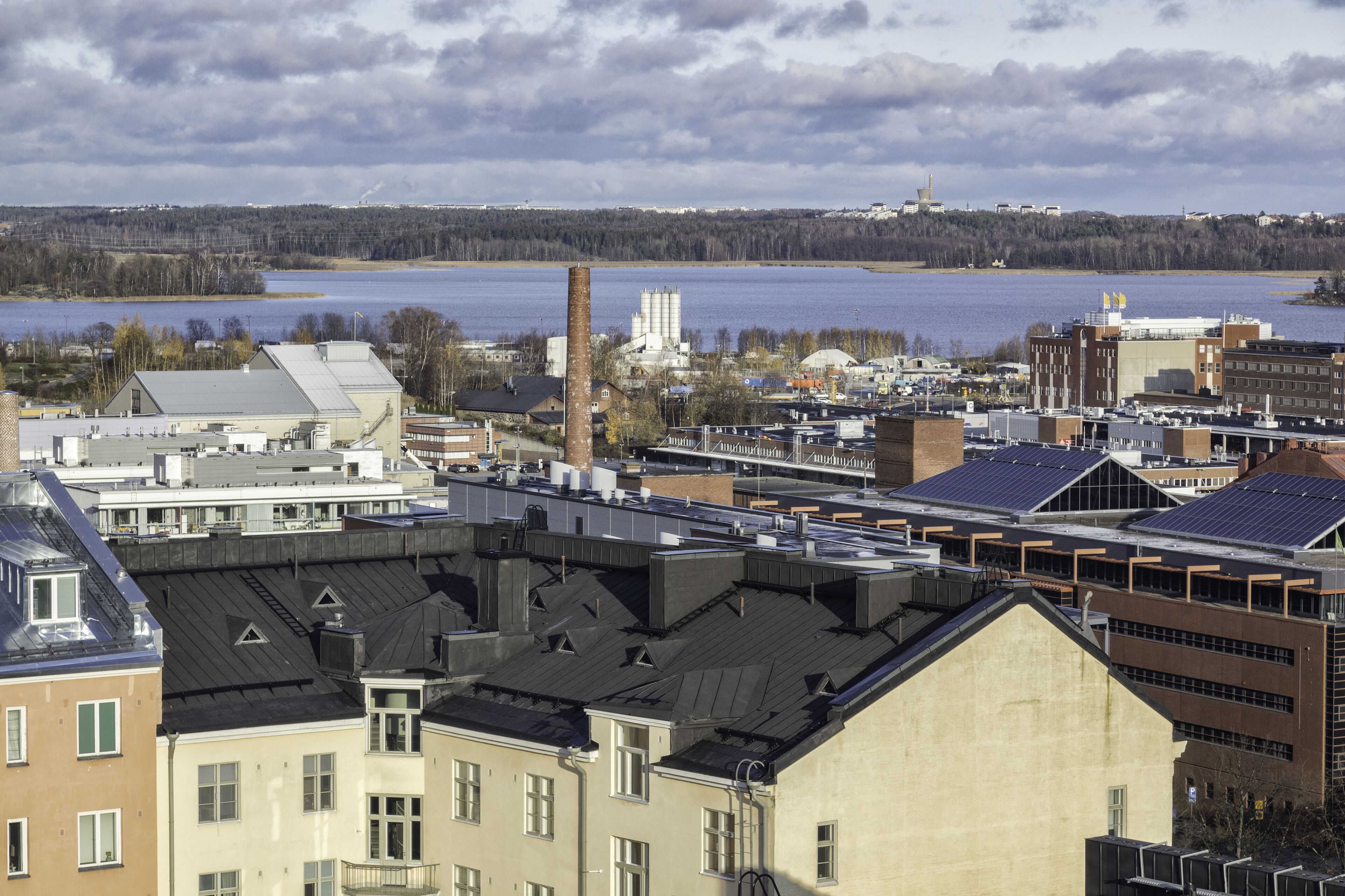 A cityscape with buildings, a river, and a distant tower.