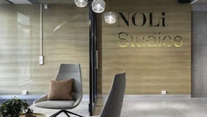 A modern interior with a wall-mounted sign reading "NOLi Studios". - Noli Sörnäinen (Helsinki)