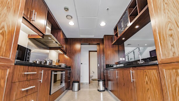 Een moderne keuken met houten kastjes, roestvrijstalen apparatuur en een centraal eiland.