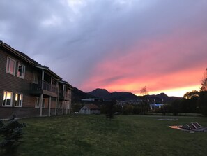 A residential area with a two-story house, a grassy yard, and mountains in the background. - Førde Gjestehus og Camping (Sunnfjord)
