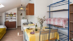 Ein kompakter Wohnraum mit Etagenbett, Küchenzeile und Essbereich.