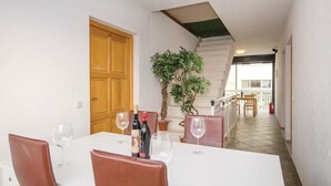 A dining area with a white table, brown chairs, and two potted plants. - Apartments Ciovo (Okrug)
