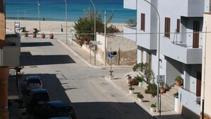 Una calle costera con vista al mar, un área de estacionamiento y edificios con balcones.