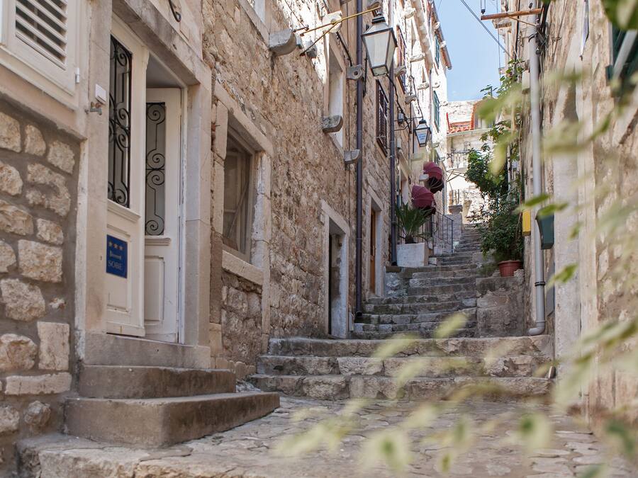 Un escalier étroit en pierre mène à un bâtiment sur lequel est apposée une enseigne indiquant un classement de 4 étoiles.