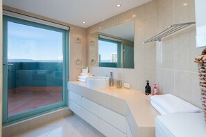 A modern bathroom with a large sink, a mirror, and a glass shower enclosure.
