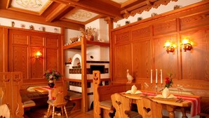 Ein traditioneller Essraum aus Holz mit hohen Decken, fest eingebauten Regalen und einem Kamin.