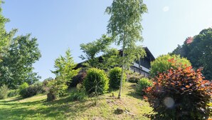 Ein Haus, umgeben von üppiger Vegetation und Bäumen.