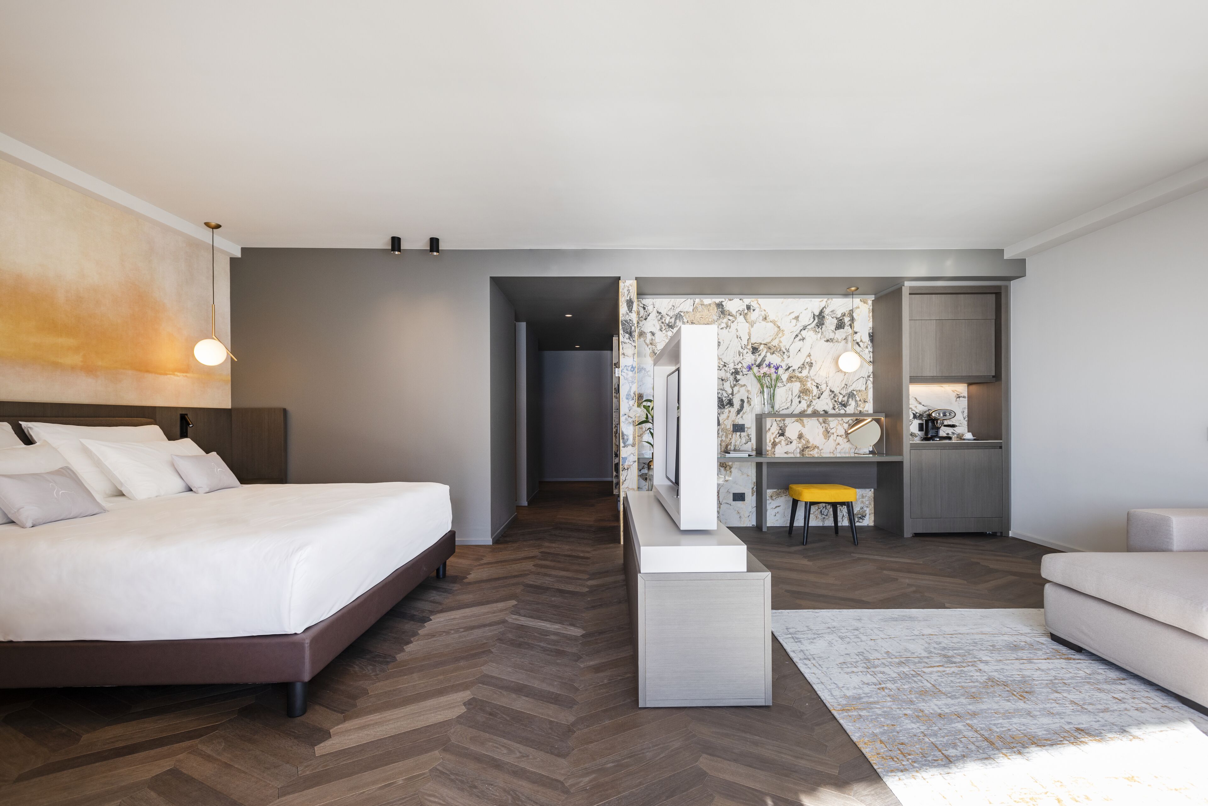 Una camera d'albergo moderna con un letto grande, un angolo cottura e vista sulla città.