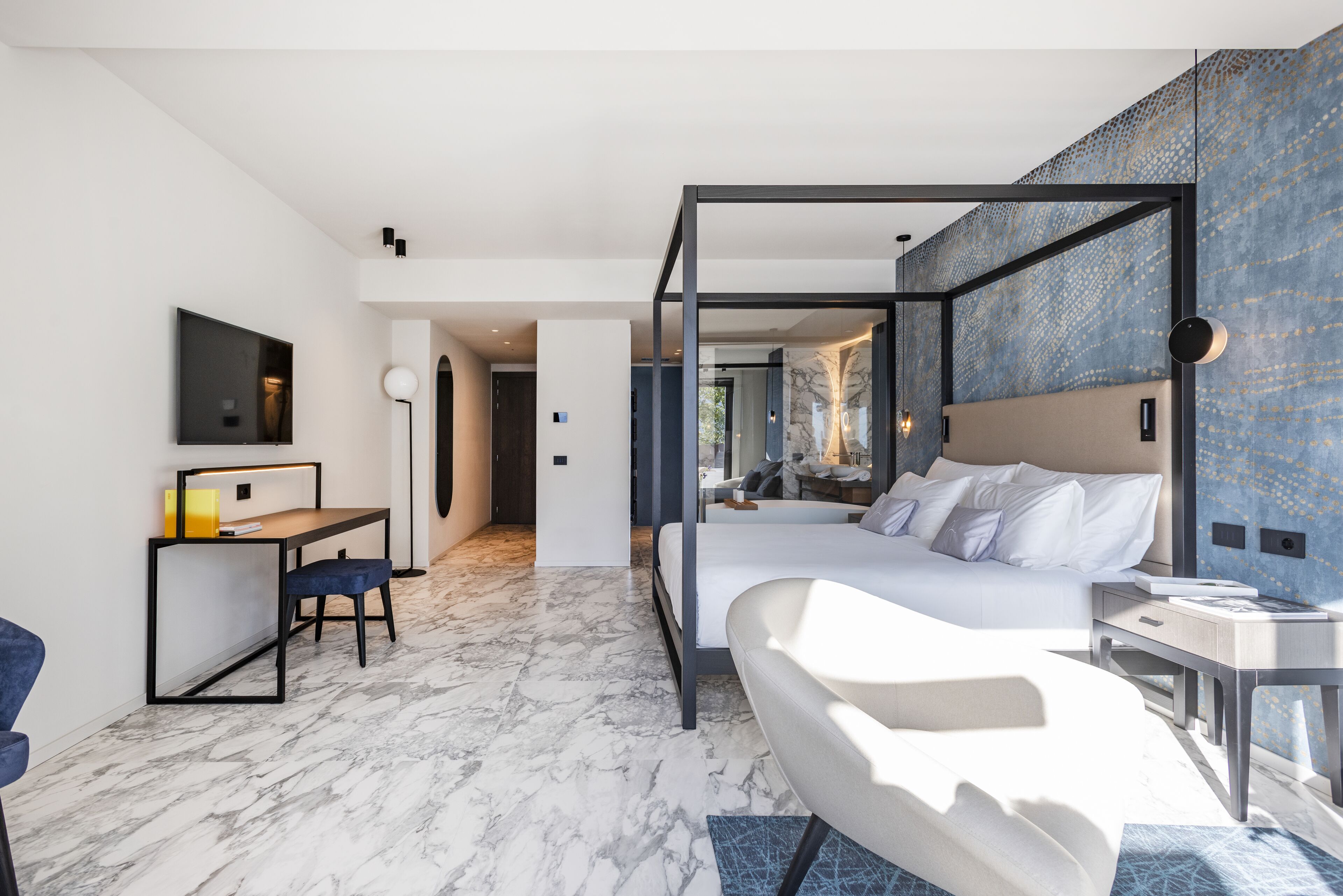 Una camera d'albergo moderna con un letto grande, una scrivania e una TV.