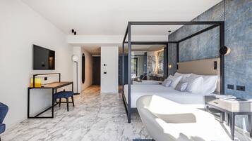 Una camera d'albergo moderna con un letto grande, una scrivania e una TV.