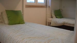 A bedroom with a single bed and a bunk bed. - 70's Hostel (Mafra)