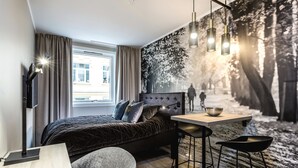 A modern bedroom with a large bed, a desk with a chair, and a large window. - New Studio Prime Location (Oslo)