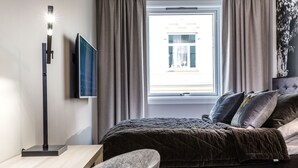 A modern bedroom with a bed, a desk, and a TV. - New Studio Prime Location (Oslo)
