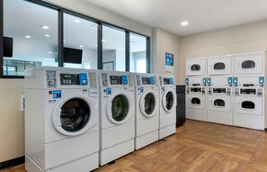 A laundry facility with multiple washing machines and dryers, arranged in rows. - Extended Stay America Premier Suites Phoenix Chandler Downto (Chandler)