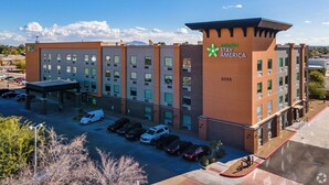 A Stay America extended hotel with multiple floors, a parking lot, and a clear sky. - Extended Stay America Premier Suites Phoenix Chandler Downto (Chandler)