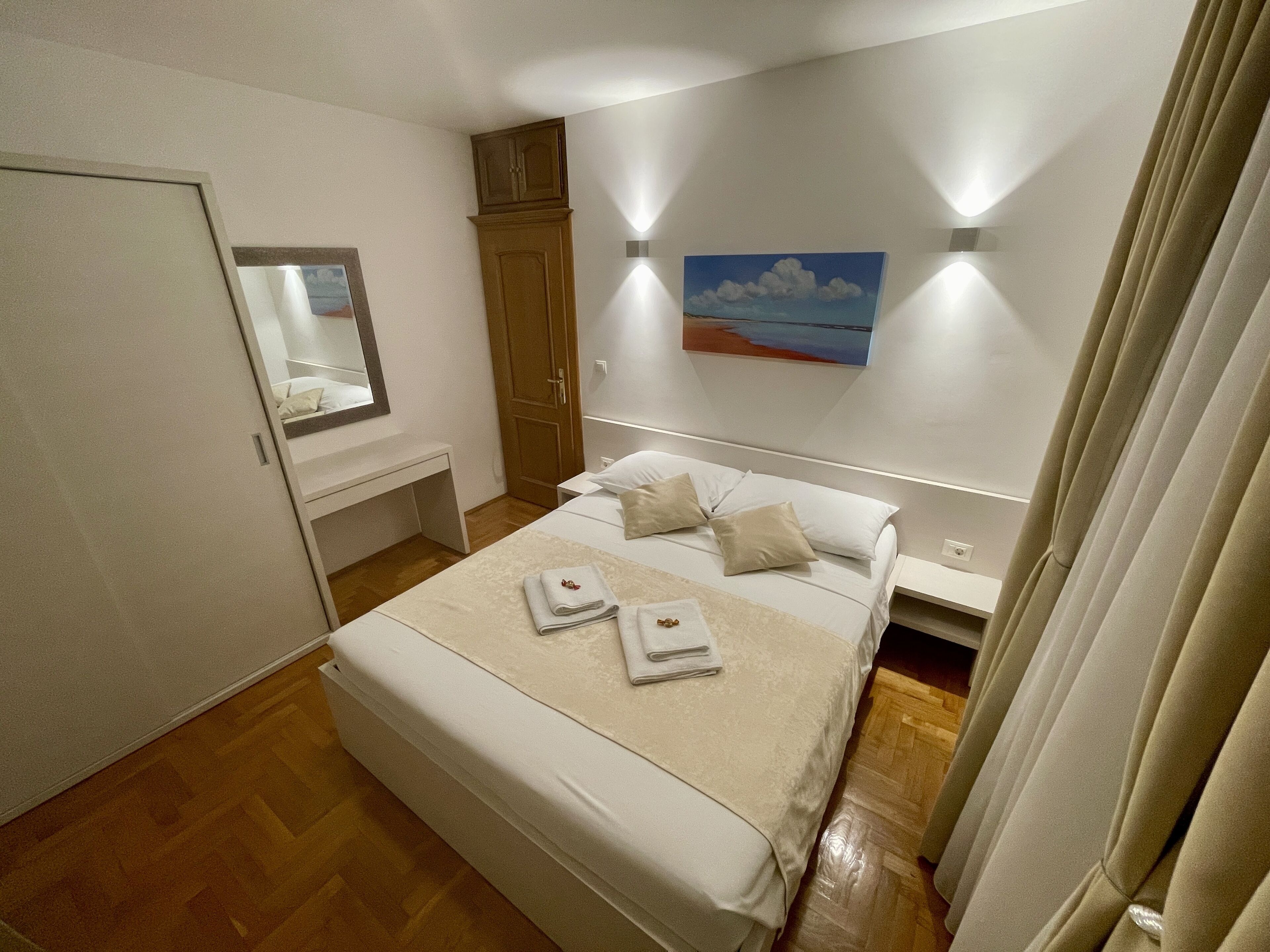 A neatly arranged bedroom with a bed, bedside table, and a wardrobe.