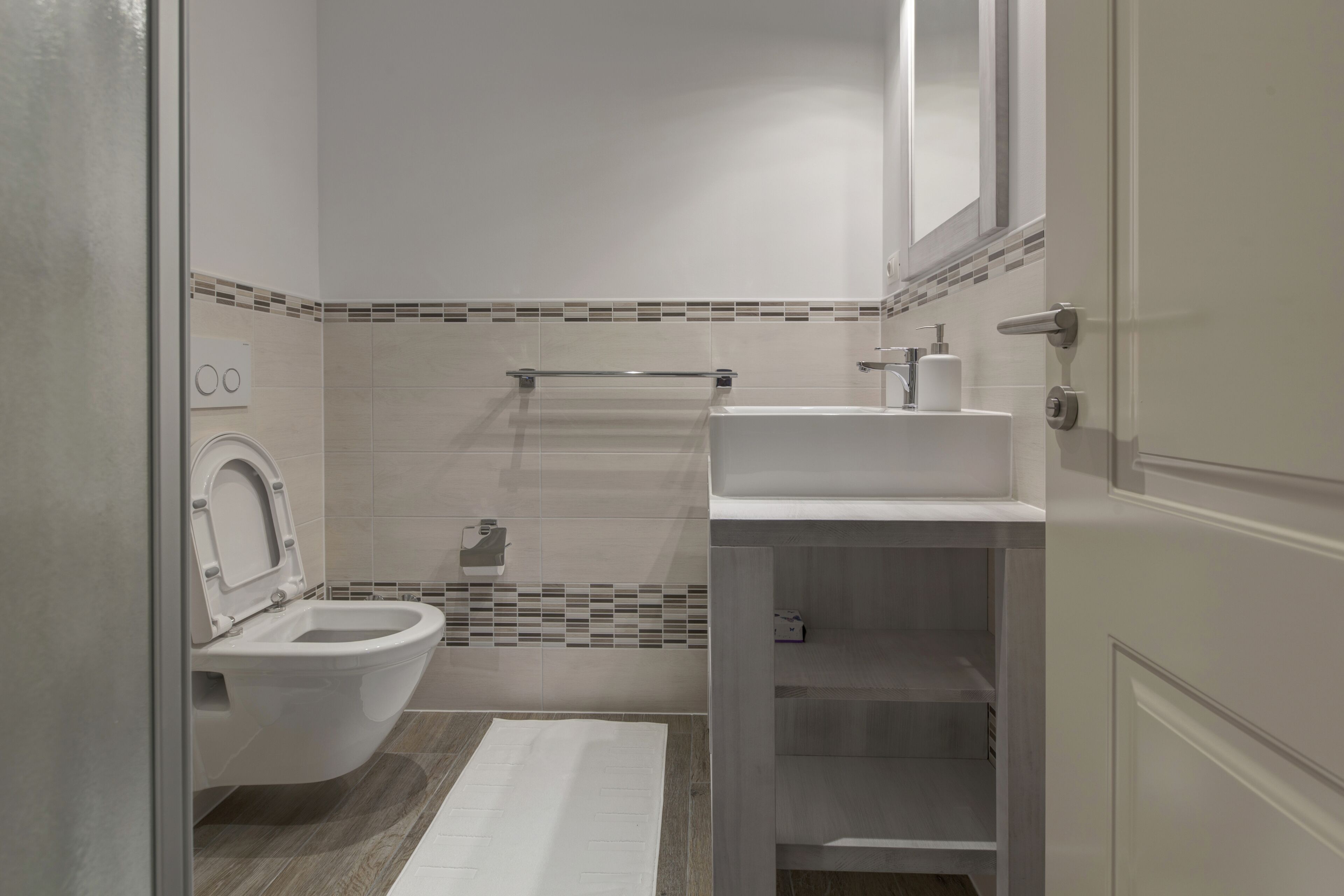 A modern bathroom with a toilet, sink, and shower area.