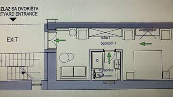 Plano de un hotel que muestra un acceso por un patio interior, una habitación individual, un baño y una zona de cocina.