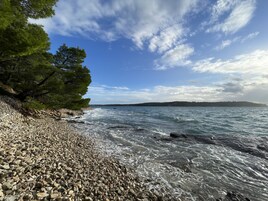 Una playa cerca, arena blanca, sillas reclinables de playa, sombrillas