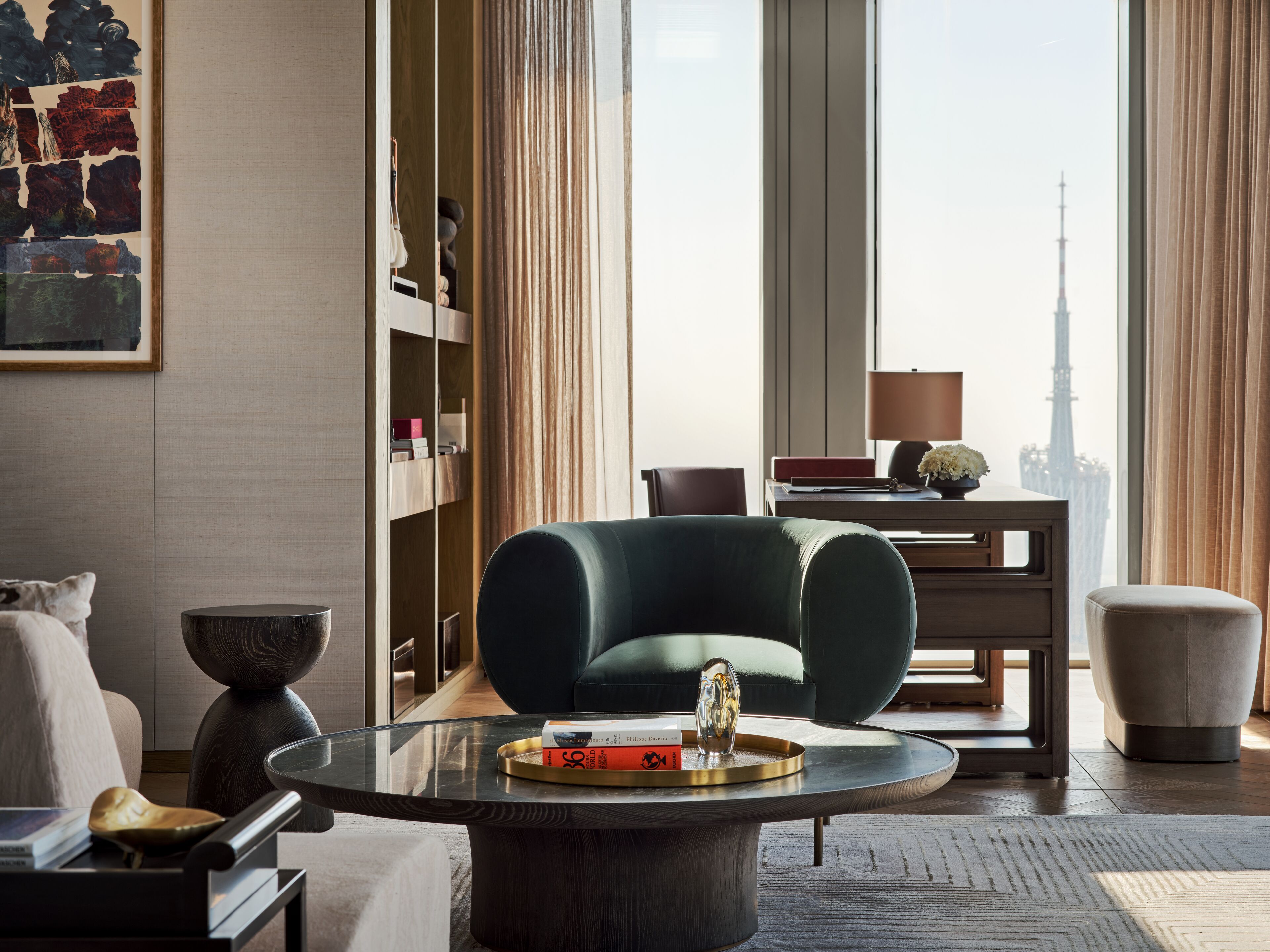 Un salon moderne avec une table basse en verre, un fauteuil vert et une vue sur la Tour Eiffel.