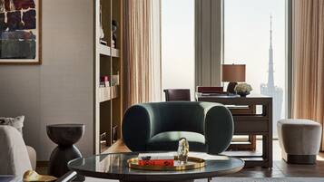 Un salon moderne avec une table basse en verre, un fauteuil vert et une vue sur la Tour Eiffel.