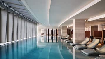Una piscina cubierta, tumbonas, socorrista en las instalaciones