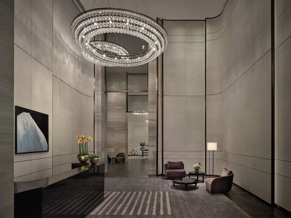 A modern lobby with a large chandelier, seating area, and a reception desk. - Rosewood Guangzhou (Guangzhou)