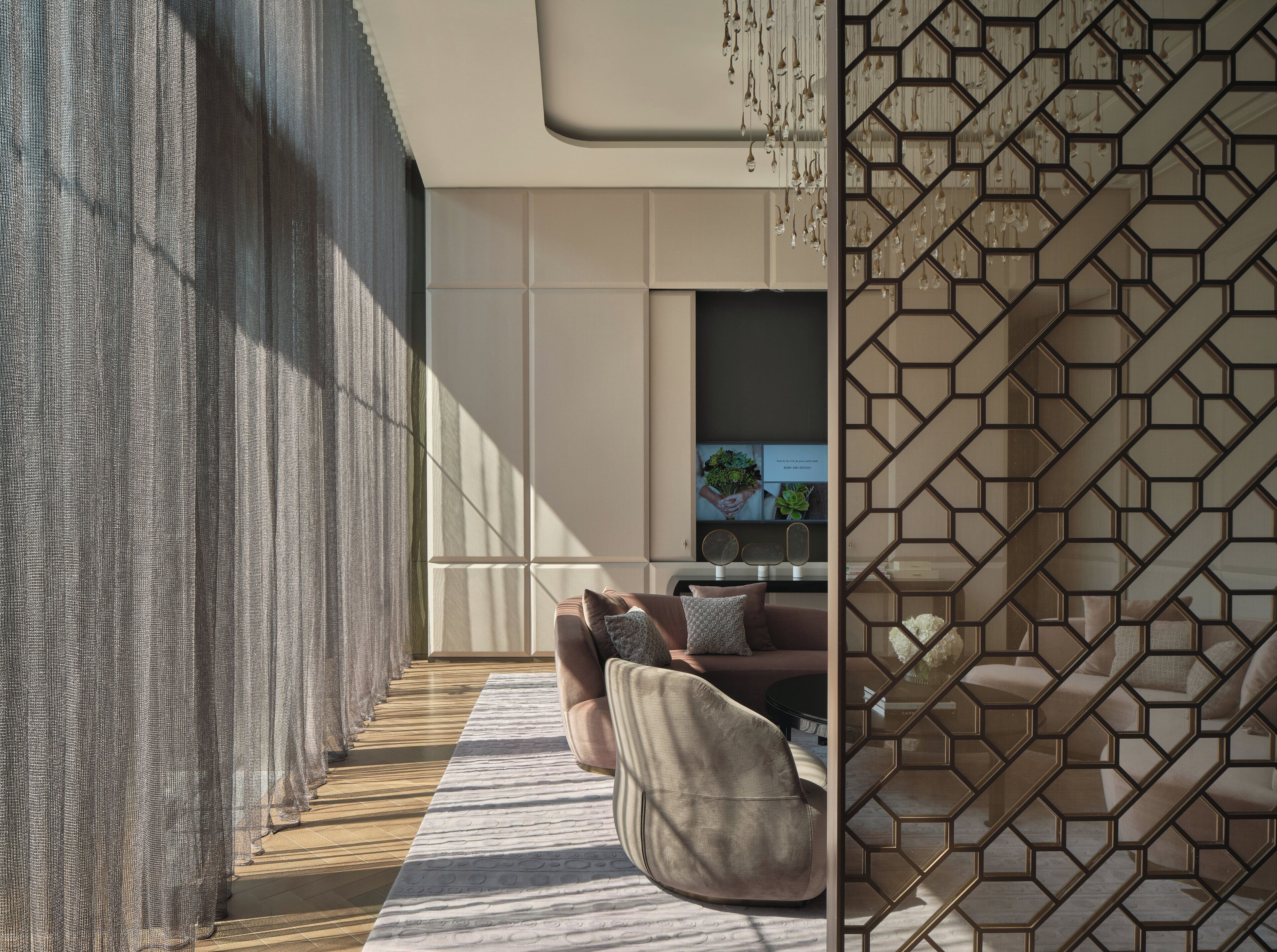 A modern interior with a sofa, a patterned rug, and a geometric wall design.