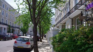 A street lined with parked cars and trees, with buildings on either side. - The London Agent Chelsea Peaceful (London)