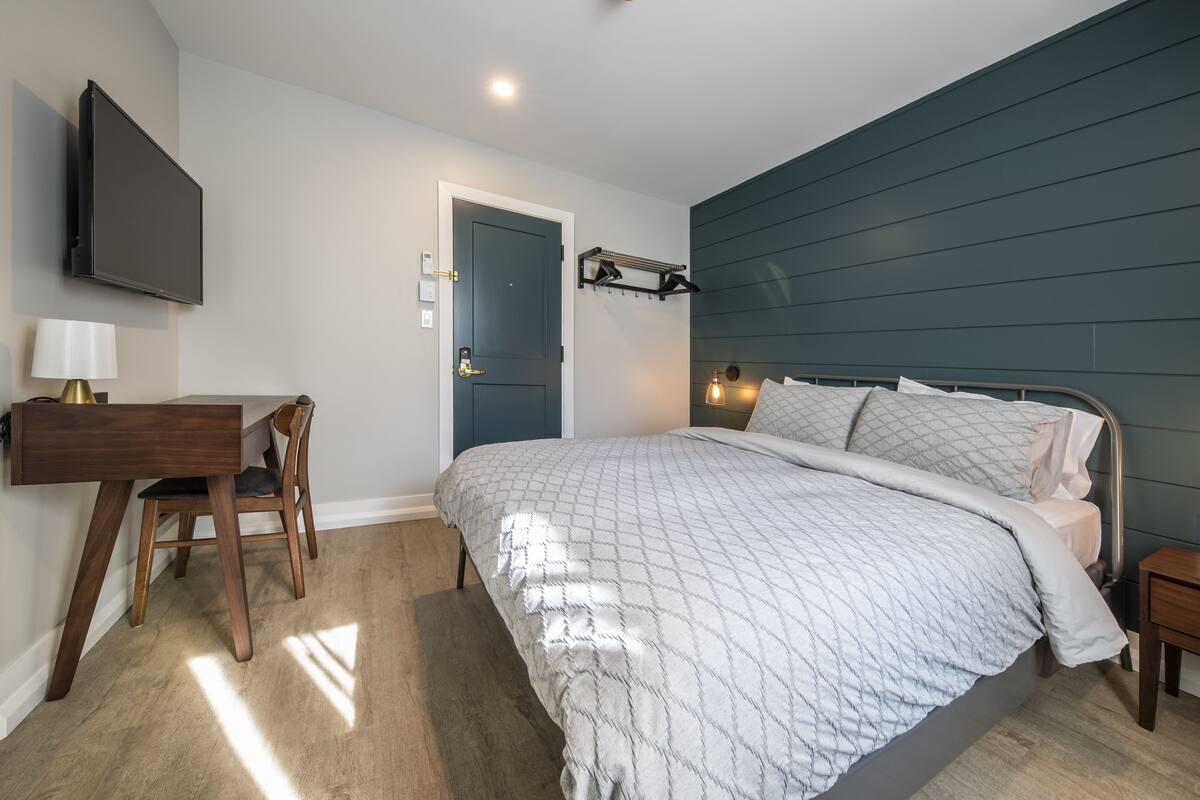 Ein Schlafzimmer mit Bett, Schreibtisch und Stuhl.