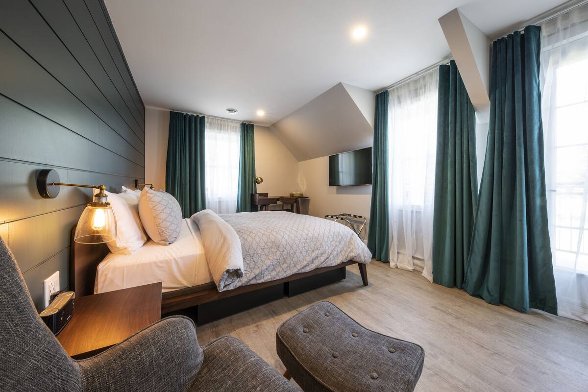 Ein modernes Hotelzimmer mit einem Bett, einer Sitzecke und einem Flachbildfernseher.