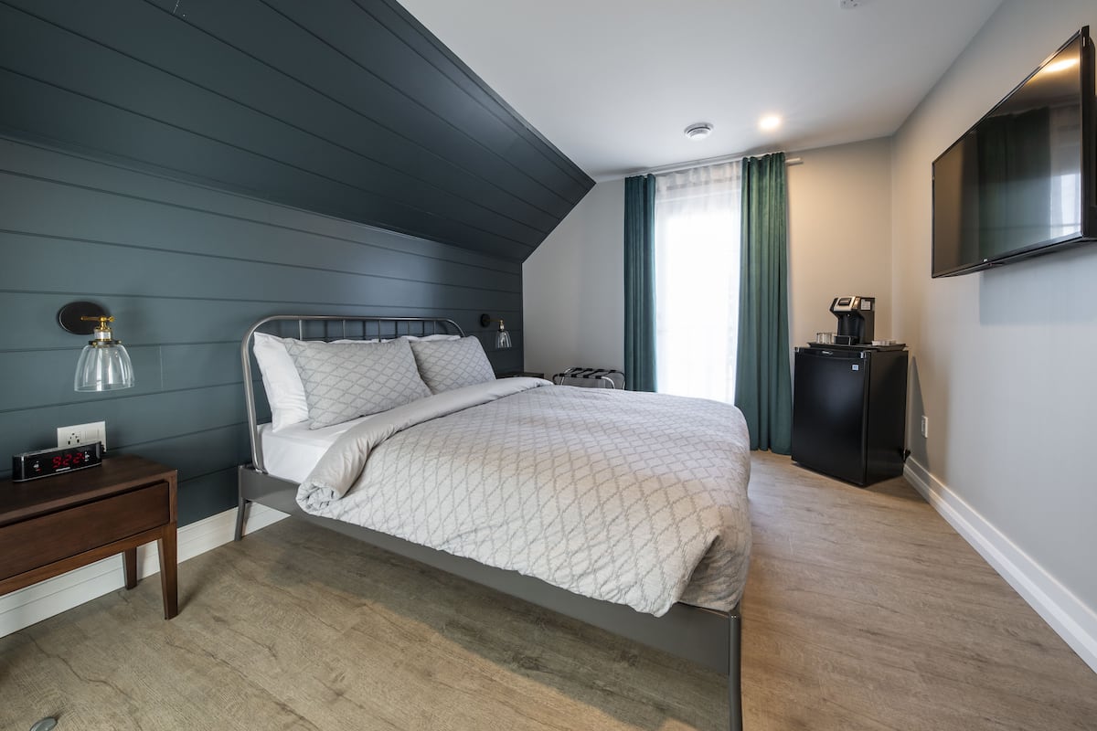Ein modernes Schlafzimmer mit Bett, Nachttisch und Flachbildfernseher.