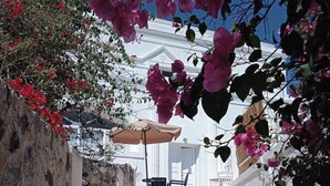 A narrow stone pathway leading to a white building with a staircase. - Loukas Kontos Traditional House (Santorini)