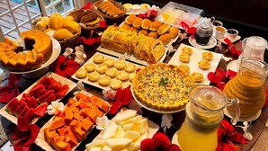 A buffet table with various food items, a coffee machine, and a beverage dispenser.