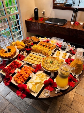 A buffet table with various food items, a coffee machine, and a beverage dispenser.