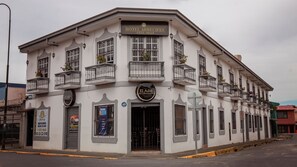 A corner building with a sign for Hotel Arrecifes and El Adri Bar y Restaurante. - Hotel Arrecifes (San José)