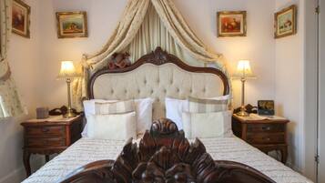 A bedroom with a large bed, two bedside tables, and a canopy bedspread.