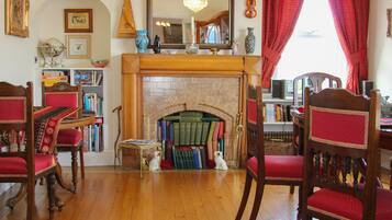 A cozy library with a fireplace, wooden furniture, and bookshelves filled with books.