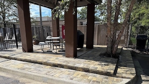 A covered outdoor seating area with stone steps leading up to a table and chairs. - Candlewood Suites Jacksonville - Mayport by IHG (Atlantic Beach)