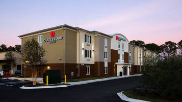 Stylish hotel with a flat roof and symmetrical facade, featuring a prominent entrance and beautifully manicured grounds.