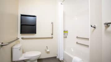 A bathroom with a toilet, a bathtub, and a shower area.