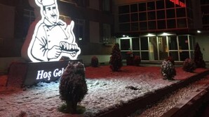 A building with a large illuminated chef figure and the name "Konukevı" in bright lights. - Mengen Belediyesi Konukevi (Mengen)