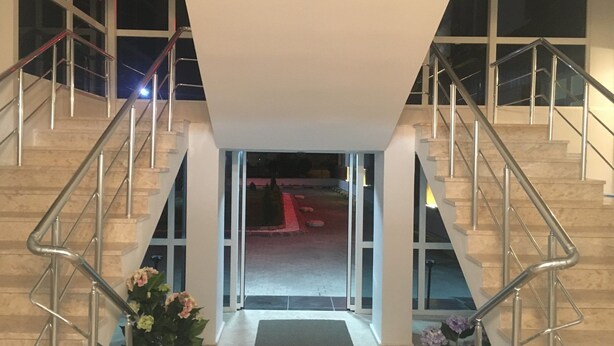 A modern building entrance with two staircases, glass doors, and a central pathway. - Mengen Belediyesi Konukevi (Mengen)