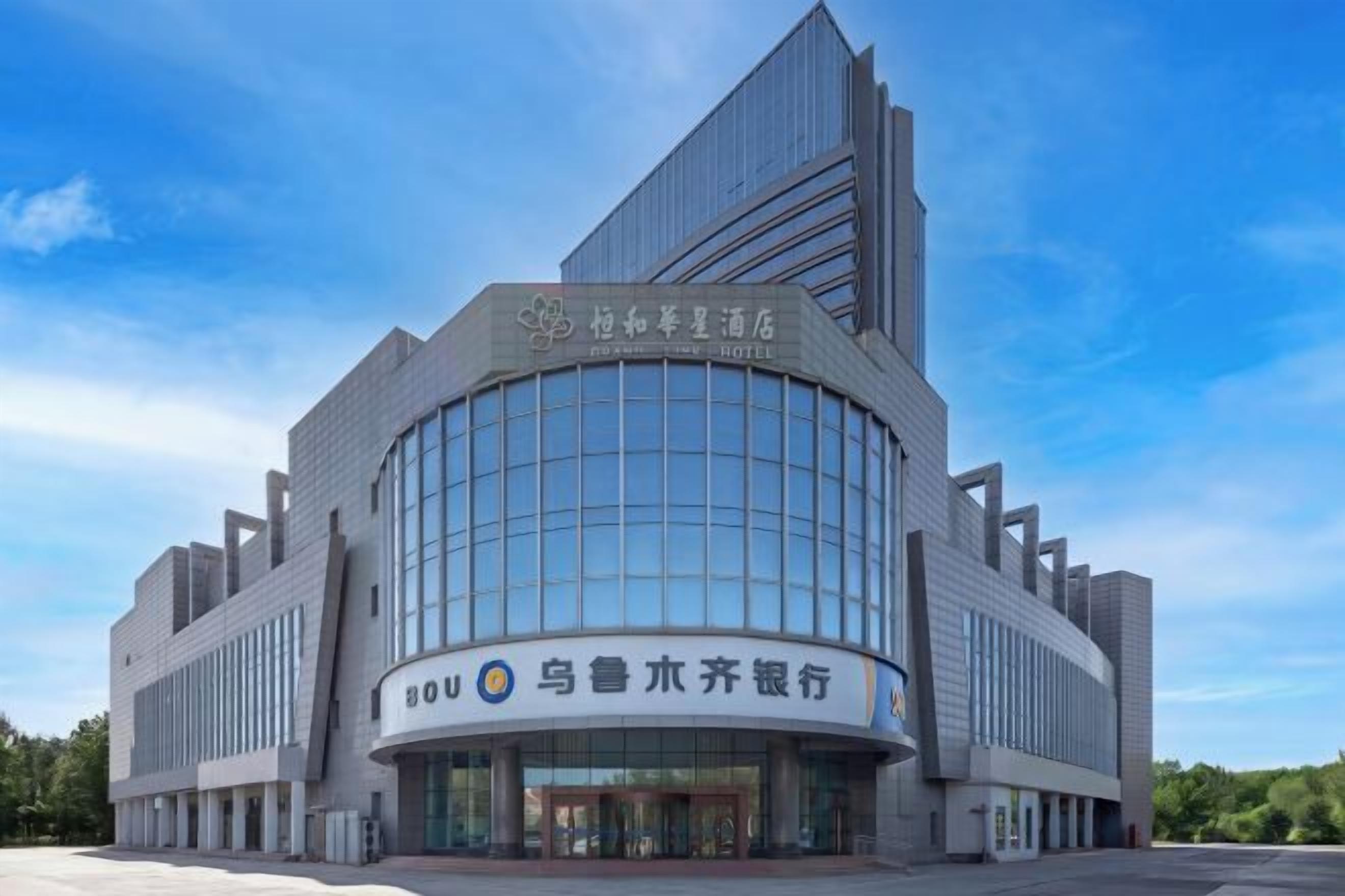 A modern hotel building with a curved facade and a prominent entrance.