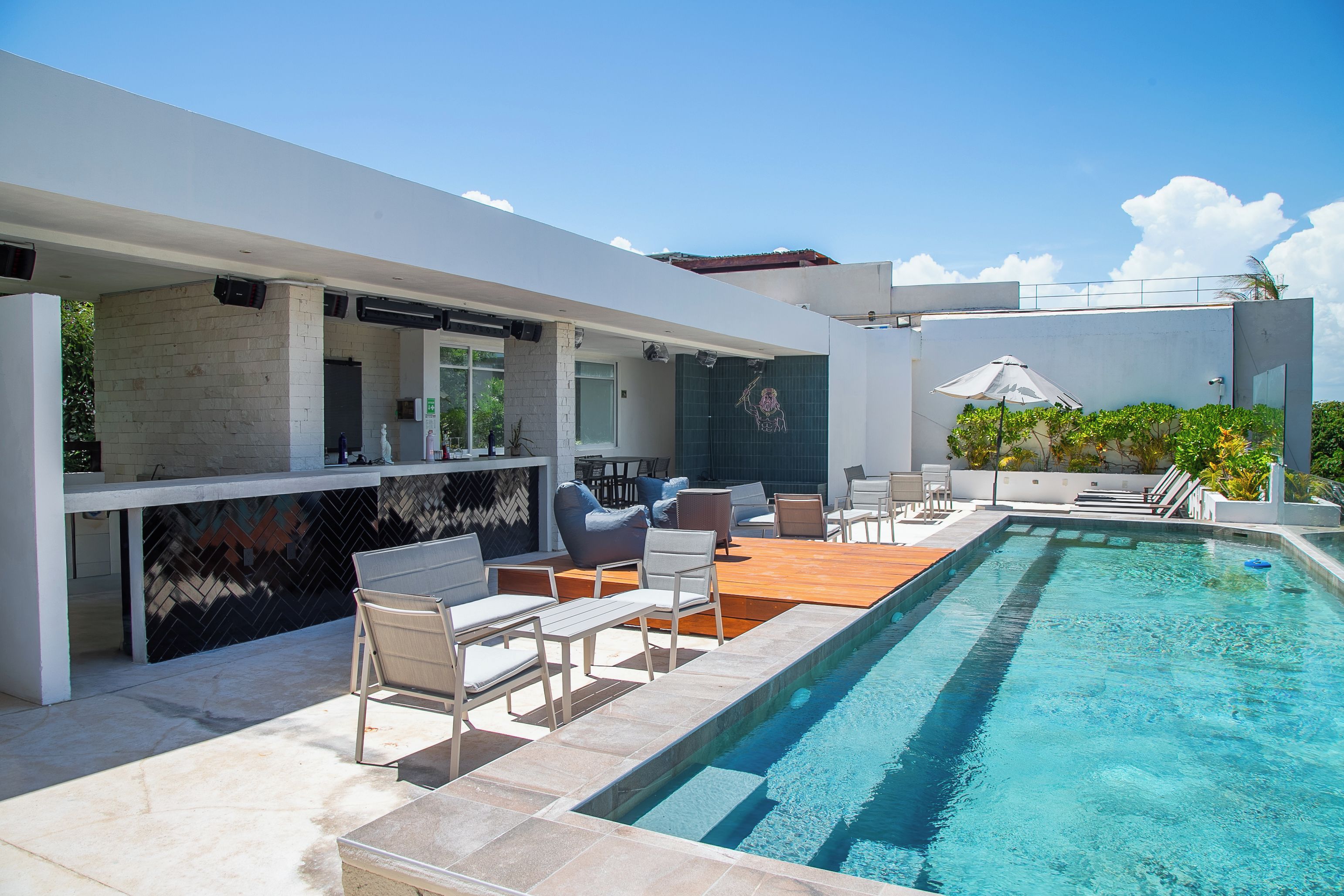 Een modern zwembad met terras, zitgedeelte en helderblauw water.