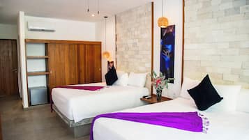 Habitación de hotel con dos camas, un armario de madera, aire acondicionado de pared y ventilador de techo.