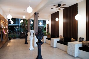 Un interior moderno con una columna central, zona de estar y un ventilador de techo.