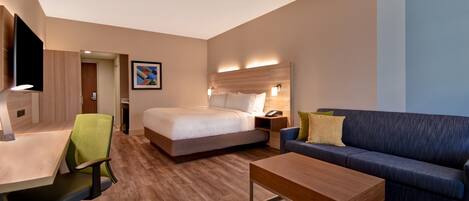 Ein modernes Hotelzimmer mit Bett, einer Sitzecke, einem Schreibtisch und einem Fernseher.