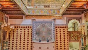 A room with intricate tile work, a central fountain, and a patterned floor. - Riad la porte bleue du palais laraichi (Fes)