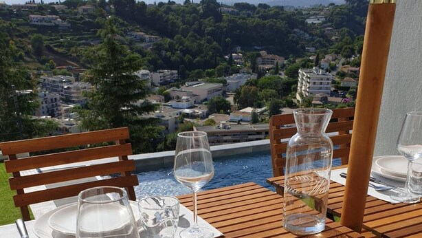 A table set for two with a view of a mountainous landscape.